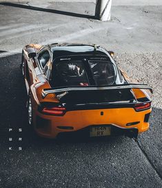 an orange sports car parked on the street