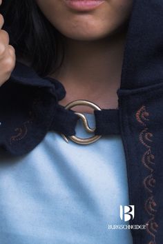 a close up of a person wearing a jacket with a ring on it's collar