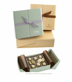 two boxes with different types of chocolates and one has a bow on the top