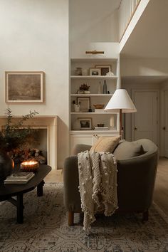 a living room filled with furniture and a fire place under a stair case next to a fireplace