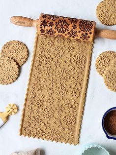 some cookies are laying out on a table next to cookie cutters and other baking utensils