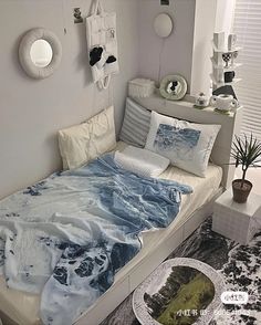 a bed room with a neatly made bed next to a window and a potted plant