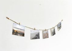 some pictures hanging on a string with clothes pins