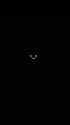 a black wall with a smiley face drawn on it's side in the dark