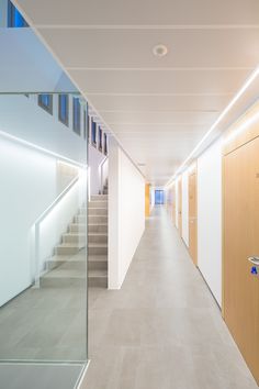 an empty hallway with wooden doors and white walls