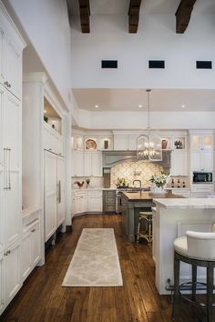 the kitchen is clean and ready to be used for cooking or entertaining, with white cabinetry and wood flooring