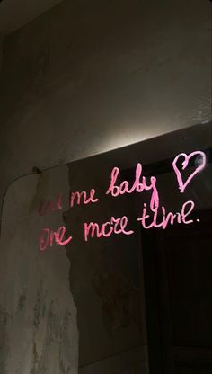 a neon sign that says i am baby one more time on the side of a wall