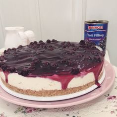 a blueberry cheesecake on a pink plate next to a can of prince's fruit filling