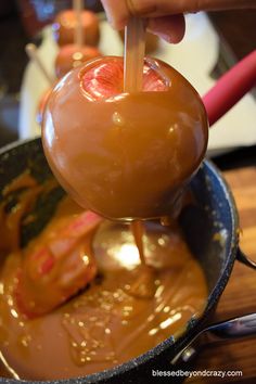 a person is dipping an apple into chocolate