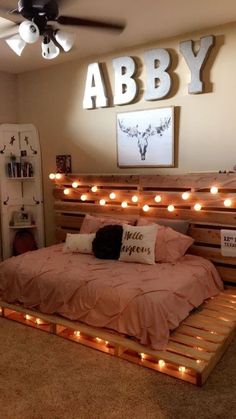 a bed made out of pallets with lights on the headboard