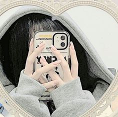 a woman taking a selfie in front of a mirror with her cell phone up to her face