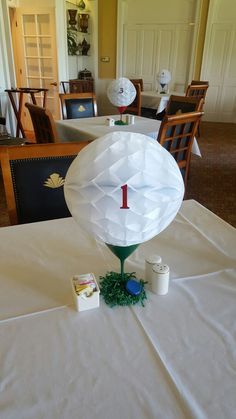 a white table topped with paper lanterns and other items on top of a cloth covered table