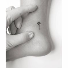 a small palm tree tattoo on the left side of the foot is shown in black and white