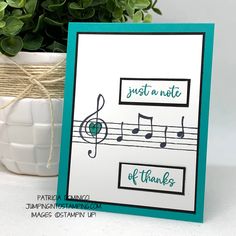 a card with music notes on it and a potted plant in the background that says just a note of thanks