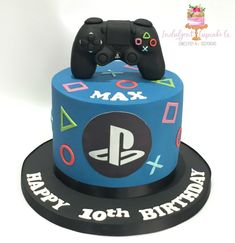 a blue birthday cake with a video game controller on the top and happy 10th birthday written in black