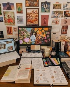 an open book sitting on top of a desk next to a computer monitor and keyboard