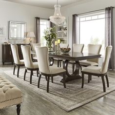 a dining room table with white chairs and a chandelier