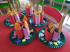 paper plates with lit candles on them sitting on a table