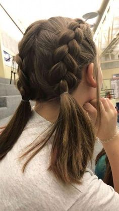 a woman with long hair braiding her hair