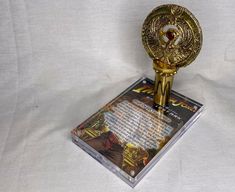 a golden trophy on top of a white sheet with an image of a man in the background