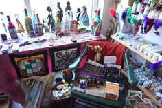 a room filled with lots of assorted items on top of a wooden table next to a window