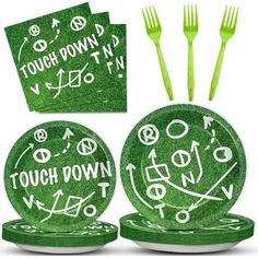 three green plates and two forks with white writing on them, along with matching napkins that say touch down now