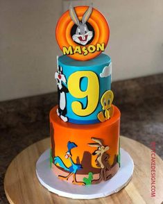 a three tiered cake with cartoon characters on it