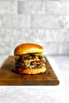 a hamburger sitting on top of a wooden cutting board