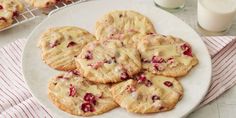 a white plate topped with cookies covered in icing next to a glass of milk