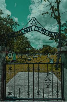 an iron gate with the word into cemetery written on it and trees in the background