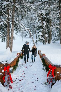 two people walking down a snowy path holding hands