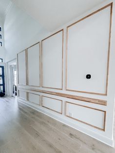 an empty room with white walls and wood trimmings on the wall, along with hardwood flooring