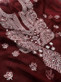 an embroidered maroon cloth with white flowers on it