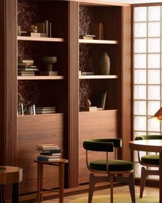 a room that has some bookshelves and chairs in it, along with other furniture