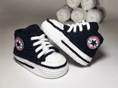 two crocheted shoes are sitting next to some balls