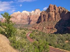 a scenic view of the mountains with a road going through it and trees on both sides