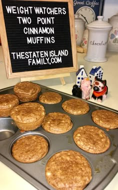 muffins sitting in a pan on top of a counter next to a sign that says weight watchers two point cinnamon muffins the state island family com