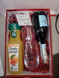 an open red box containing two bottles of orange juice and some other condiments