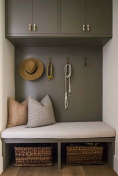 a bench with two baskets and hats on the wall above it, along with other items