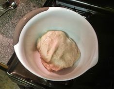 a white bowl filled with food sitting on top of a stove next to an oven