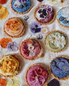 there are many different types of pies on the table with flowers in them,