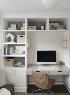 a white desk with a computer on top of it in front of a bookshelf