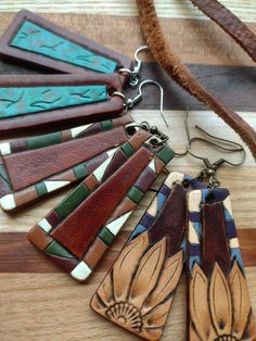 several pieces of leather are laying on a wooden table with other items in the background