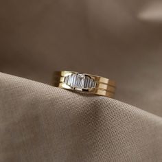 a gold wedding band with three baguettes on it