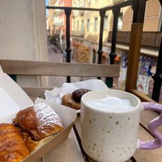 two pastries are sitting on a table next to a cup of milk and pastry