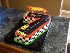 a birthday cake made to look like a race track with cars on the top and sides