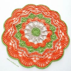 an orange and green crocheted doily