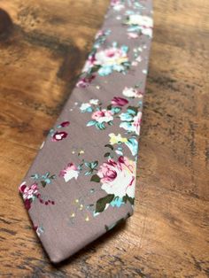 Beautiful floral tie in a dusty mauve shade with pink and blue detail. This tie would look so lovely at a spring or summer wedding, either for the groom, groomsmen, ushers or wedding guests. The fabric is soft to the touch and the colours look amazing together. Material: Polyester Size: 146cm x 6cm This item will be hand gift wrapped before posting. Dapper Suit And Tie Accessories For Spring Wedding, Spring Wedding Floral Print Suit And Tie Accessories, Black Suit Mauve Tie, Wedding Suit Accessories With Floral Print Standard Tie, Mauve Tie, Spring Wedding Floral Print Ties, Men’s Floral Tie Wedding, Floral Print Tie For Groom, Floral Print Standard Tie For Wedding