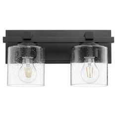 two light fixtures mounted on a wall with black brackets and clear glass shades, one bulb is