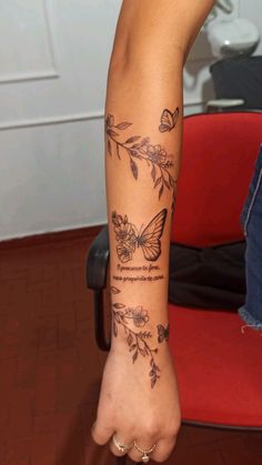 a woman's arm with tattoos on it and flowers in the middle of her arm